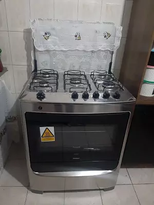 Consul CFS5N em cozinha de piso e azulejos brancos, com o vidro da mesa levantado com panos de prato pendurados.