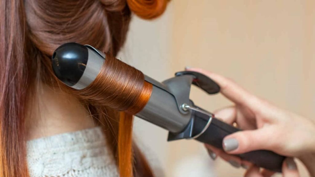 Abertura do post sobre como funciona o babyliss: Cabelereira fazendo cachos com modelador