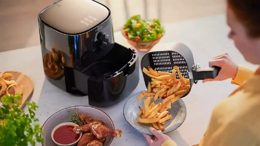 Abertura do post sobre se Air Fryer vale a pena: Mulher preparando batatas em Fritadeira sem Óleo