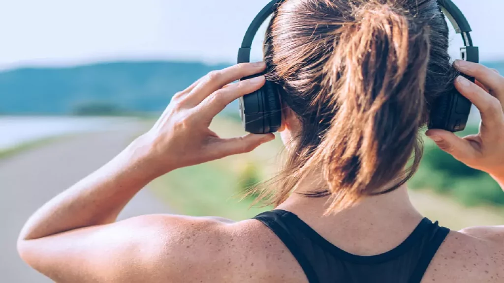 mulher praticando corrida com um headphone